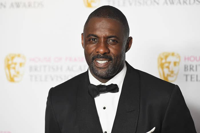 Close-up of Idris smiling in a suit and bow tie