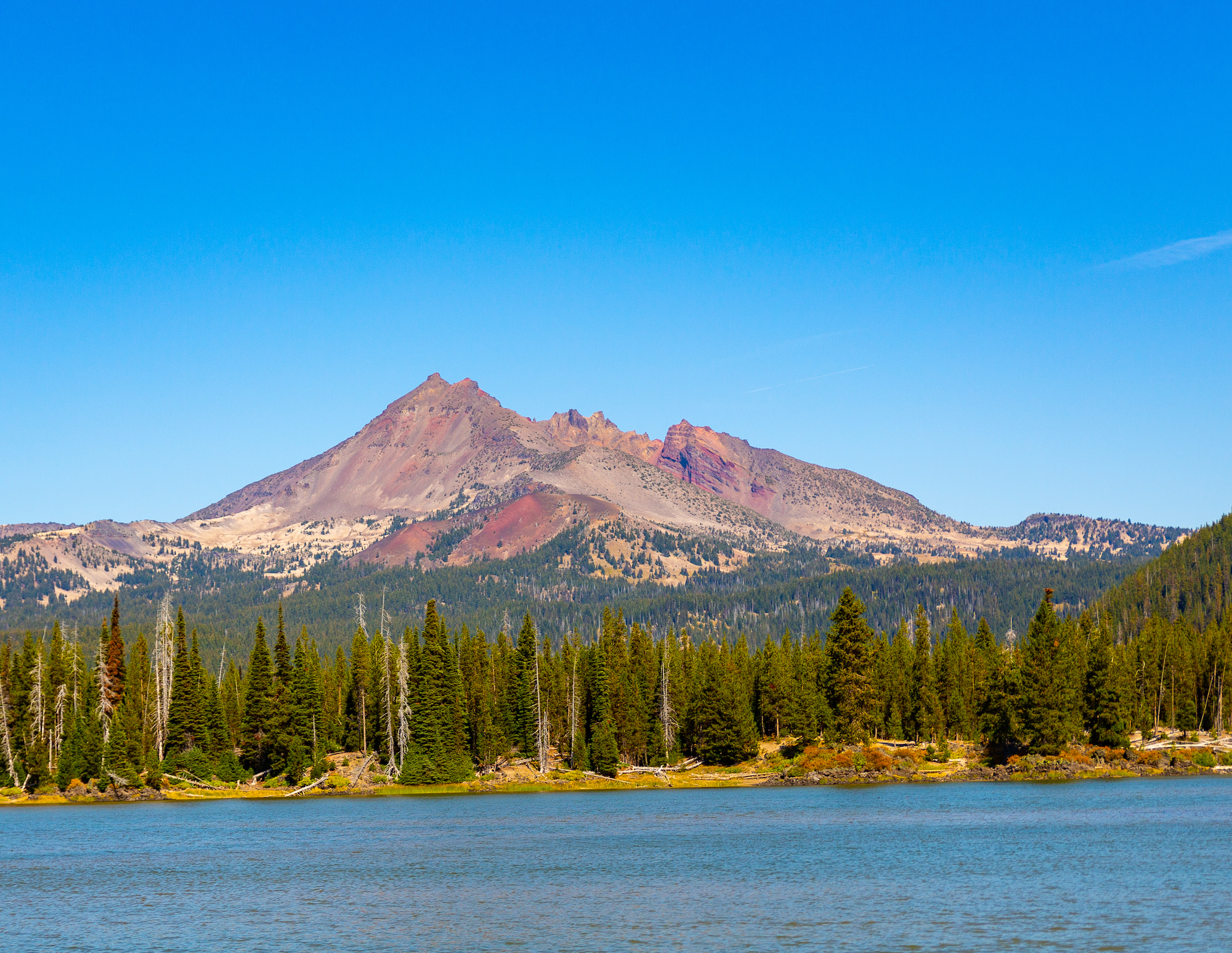 Lava Lake with tall trees around it and a mountain in the distance