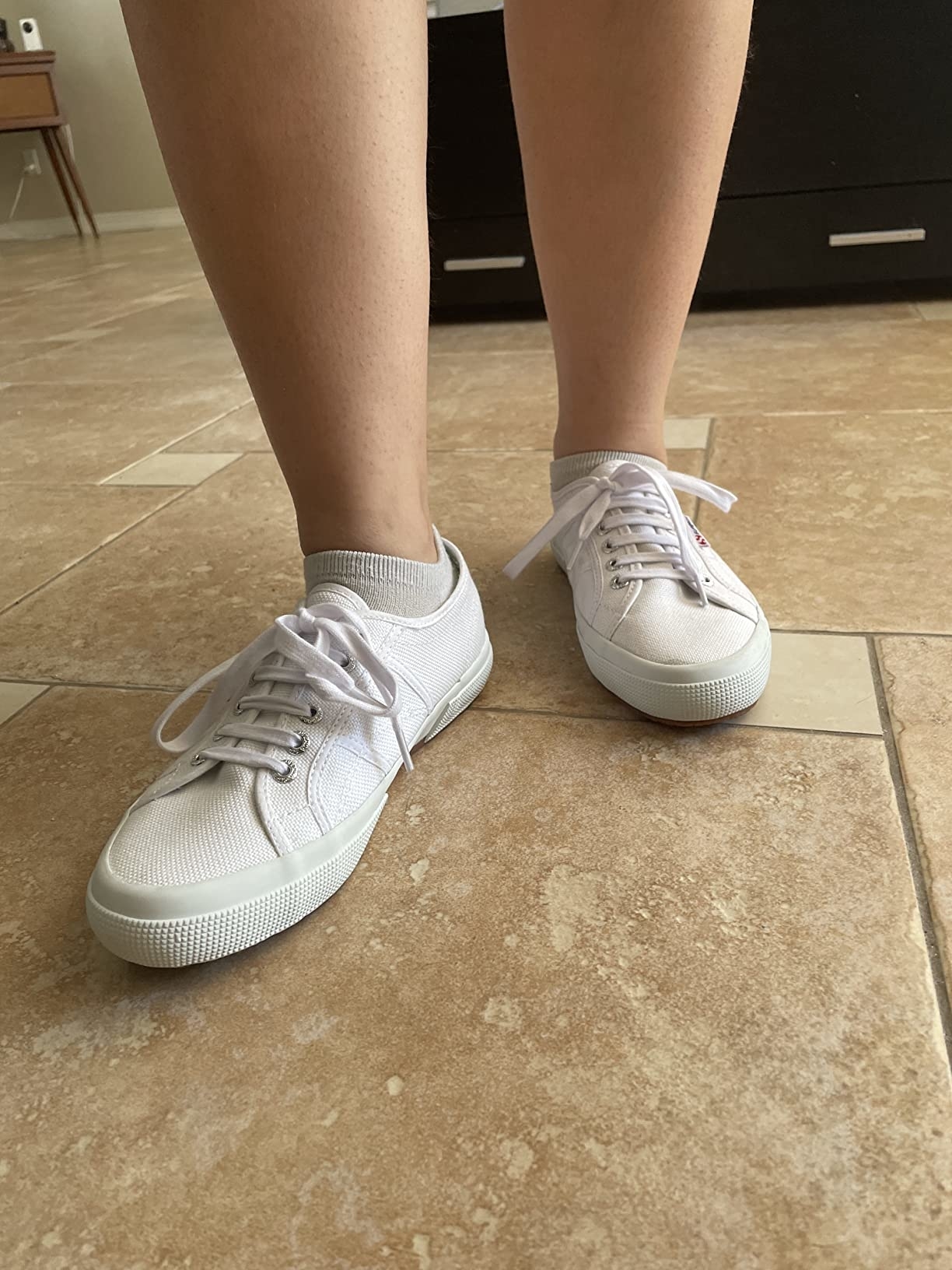 Reviewer standing wearing white sneakers with socks