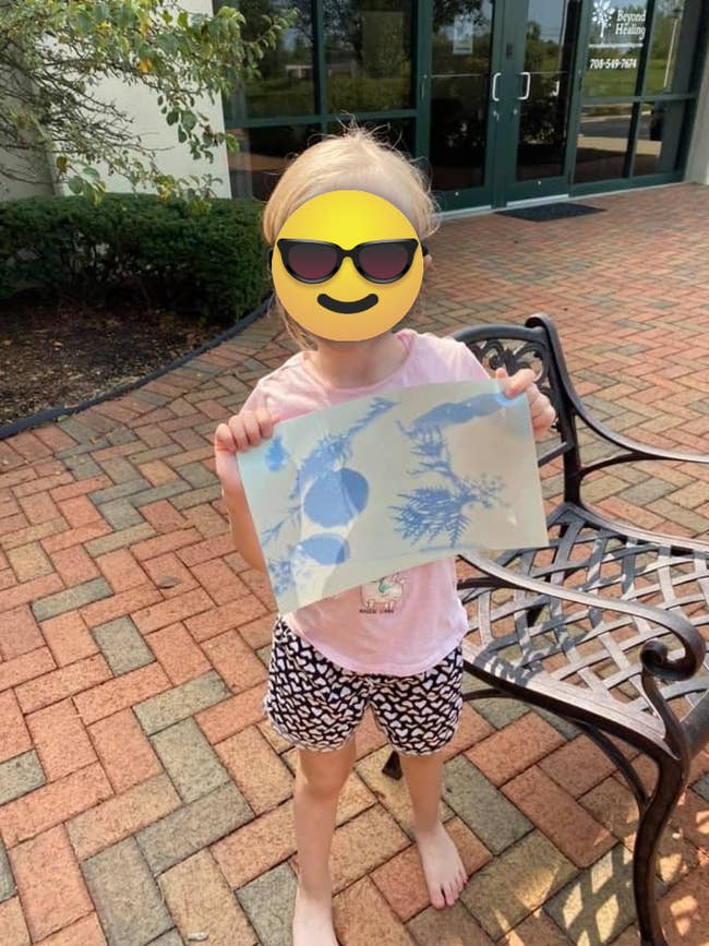 reviewer image of a child holding up their sun-printed paper