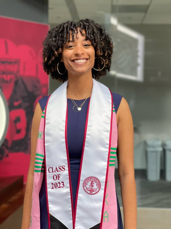 Danielle Green smiles as she wears her graduation stoles