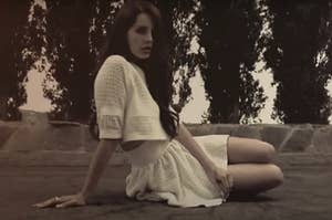 Lana Del Rey sitting on the ground in the Summertime Sadness music video