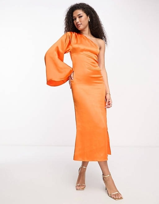 A model posing in the orange midi dress