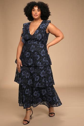A model posing in the blue lace dress
