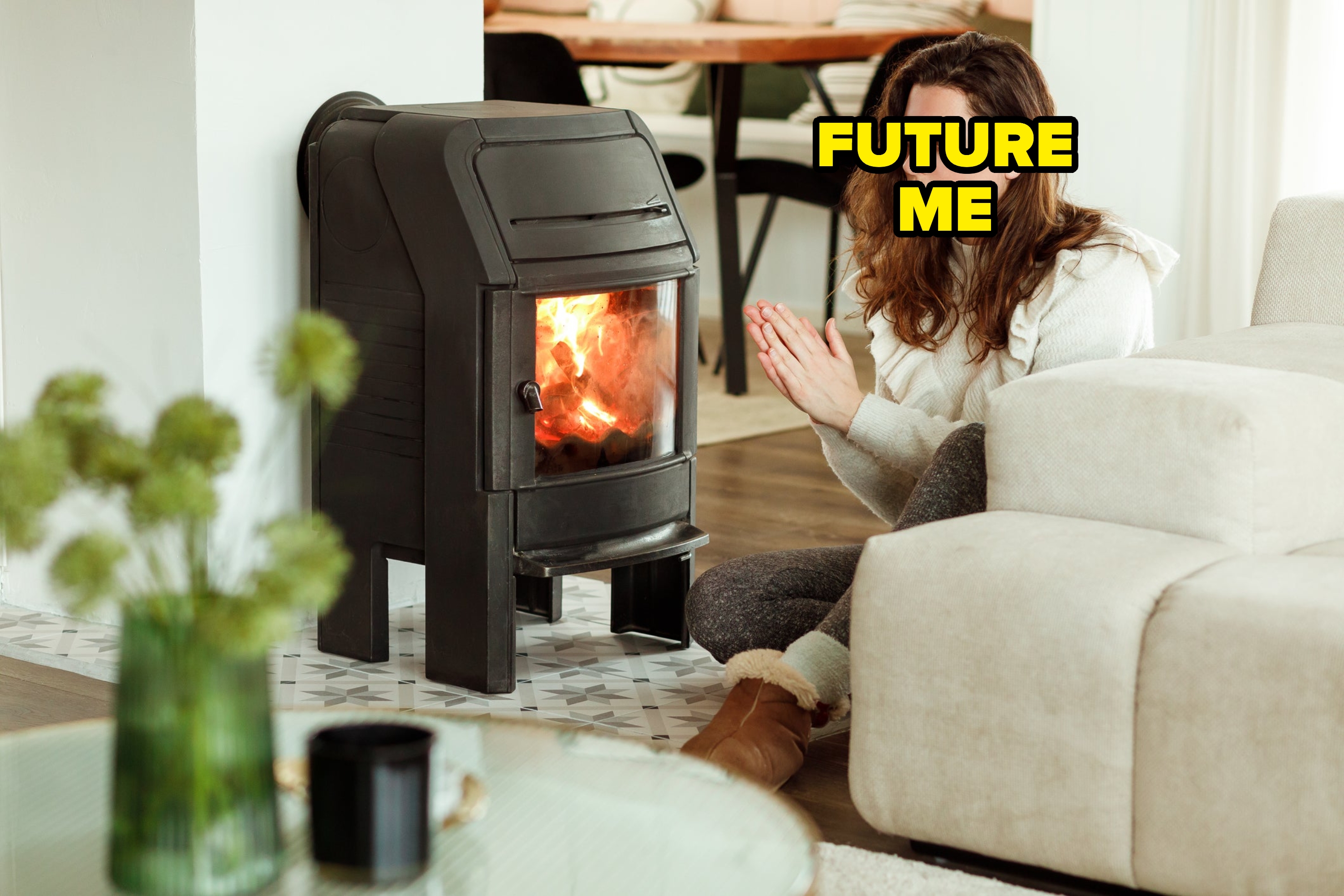 A young brunette woman trying to keep warm by warming hands near the fireplace in winter time. Energy saving project