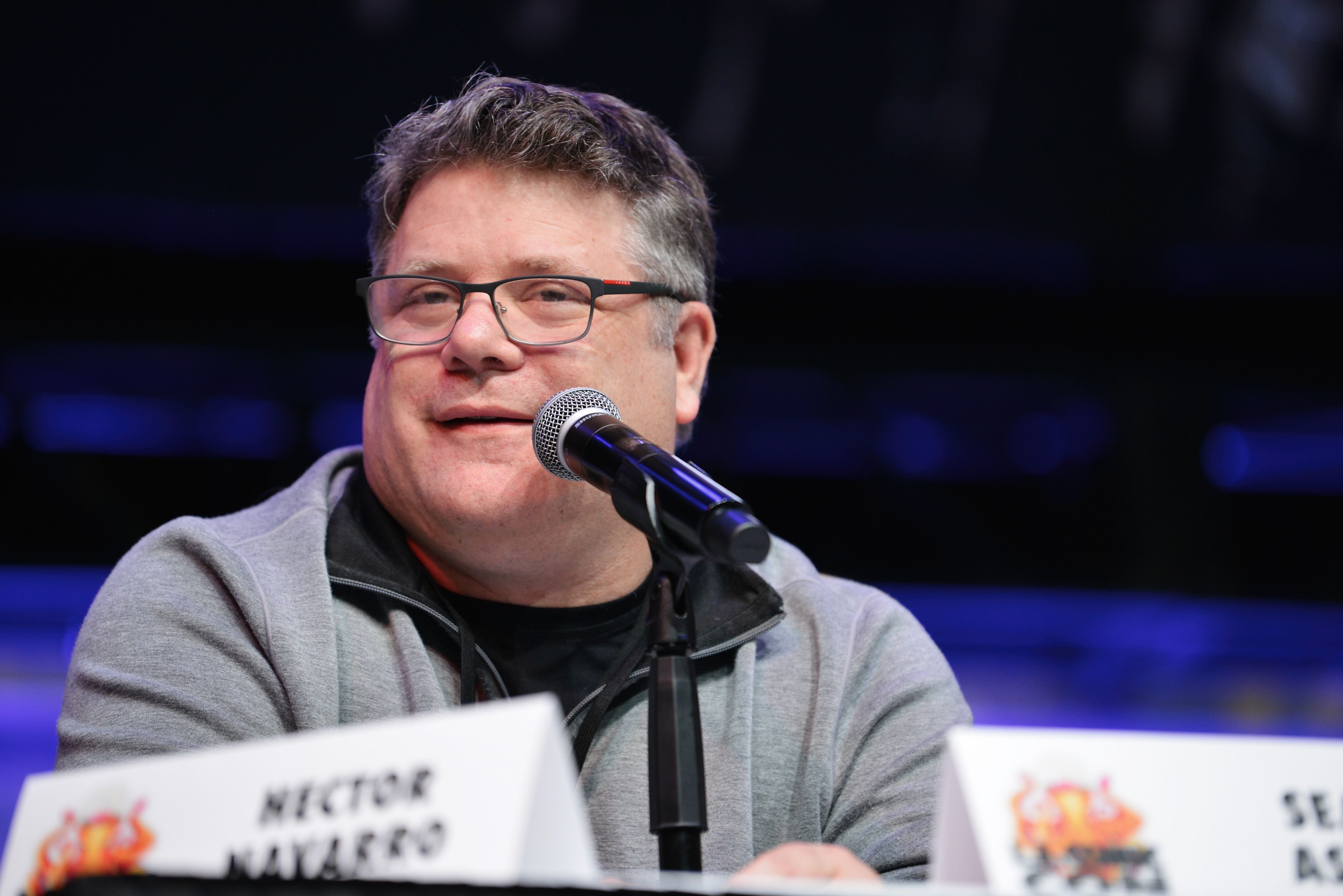 A shot of Sean Astin on a panel speaking into a microphone