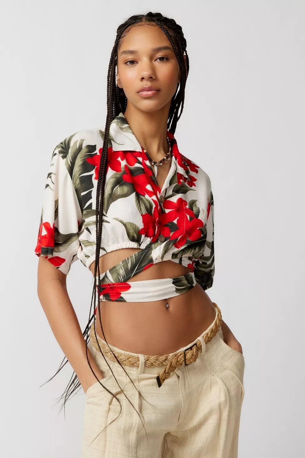 Model wearing wrap top with red and green tropical floral print