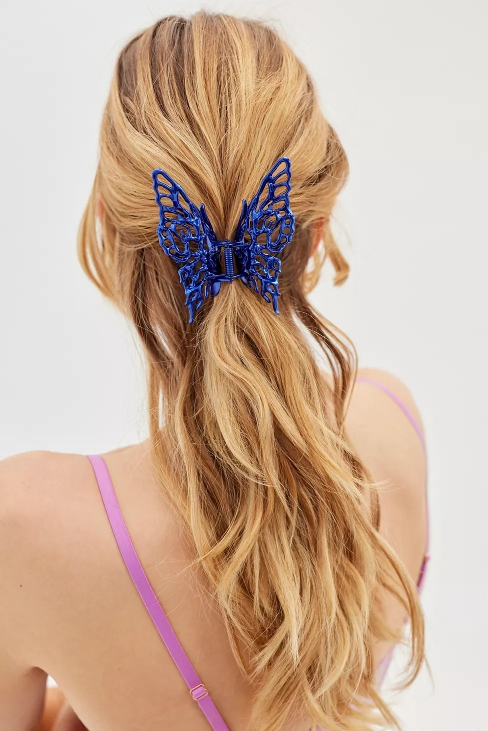 Model with blue metal butterfly clip in hair