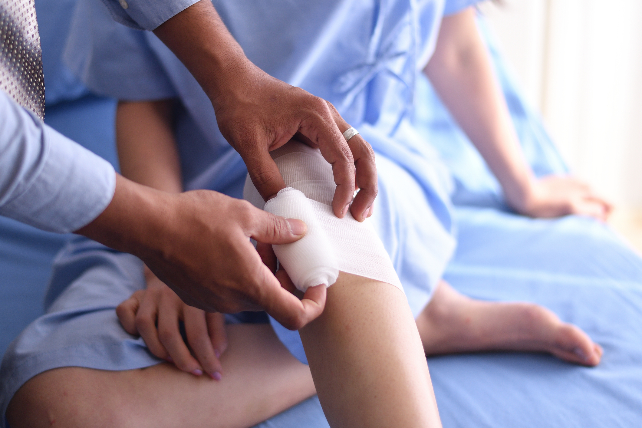 hands putting a wrap on a knee