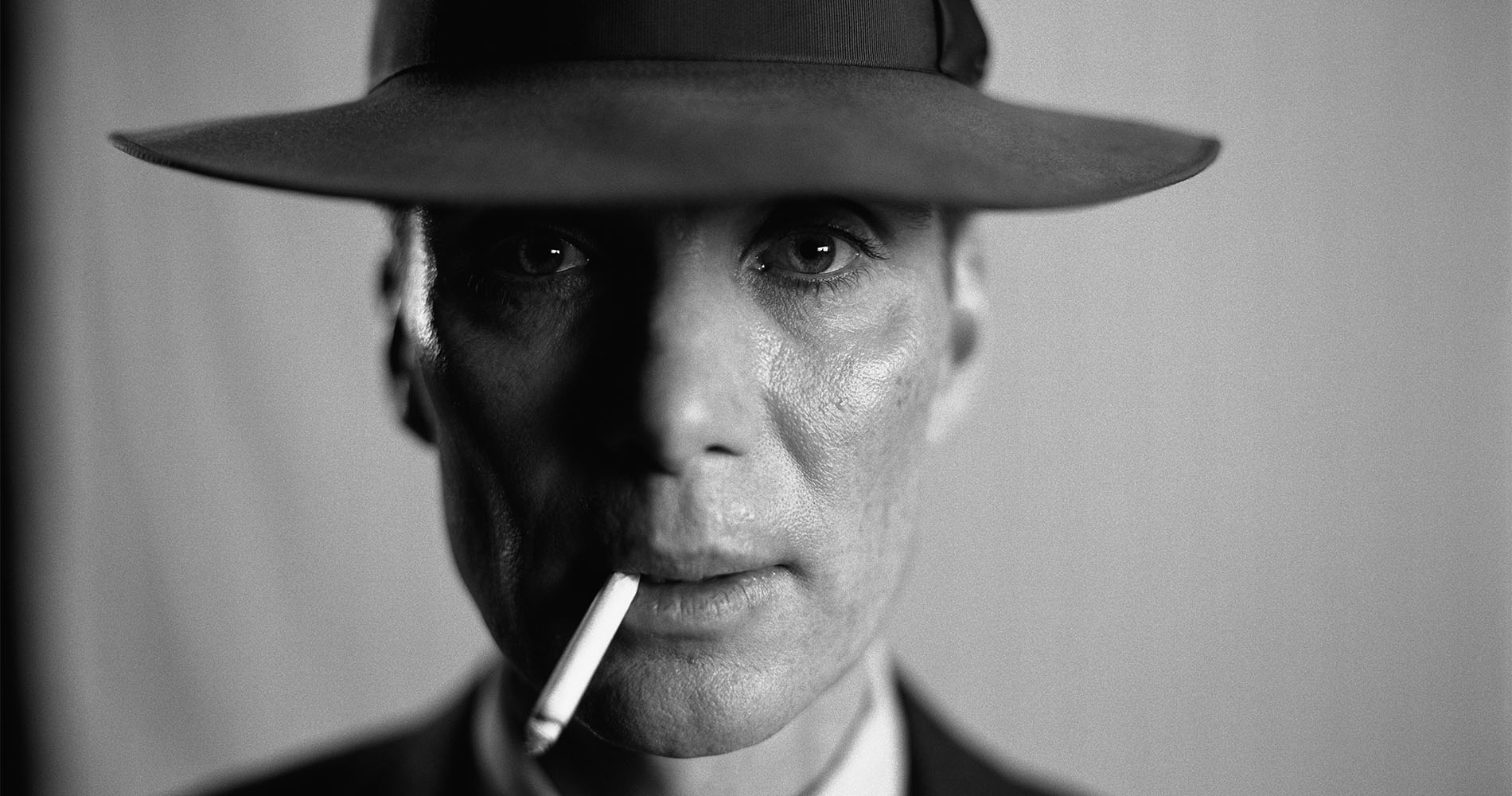 A closeup of Cillian Murphy as Oppenheimer with a cigarette hanging from his mouth