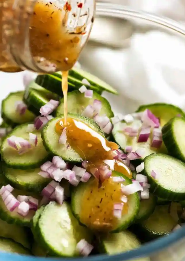 cucumber salad with garlic herb vinaigrette poured on top