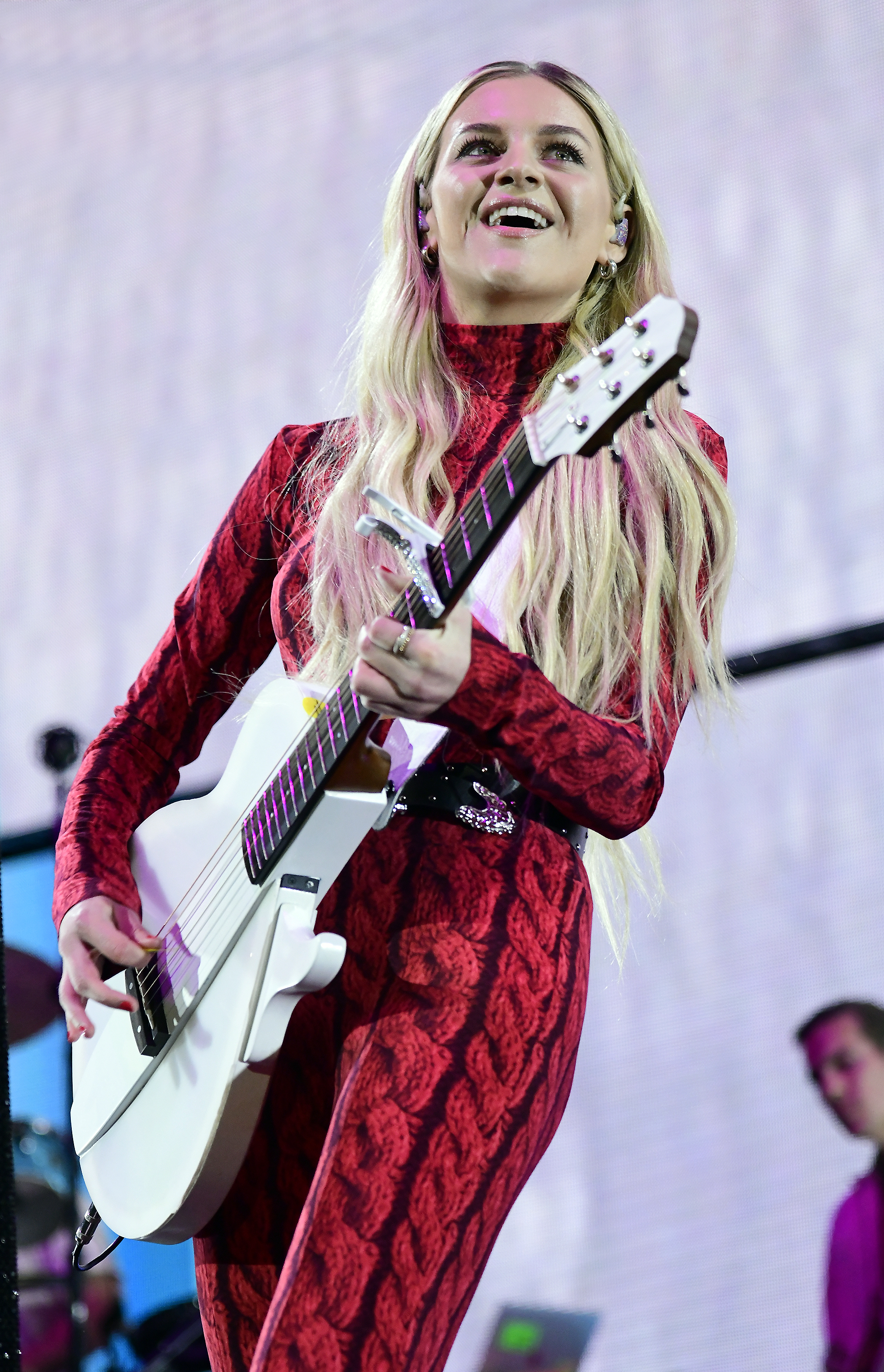 Kelsea playing the guitar on stage