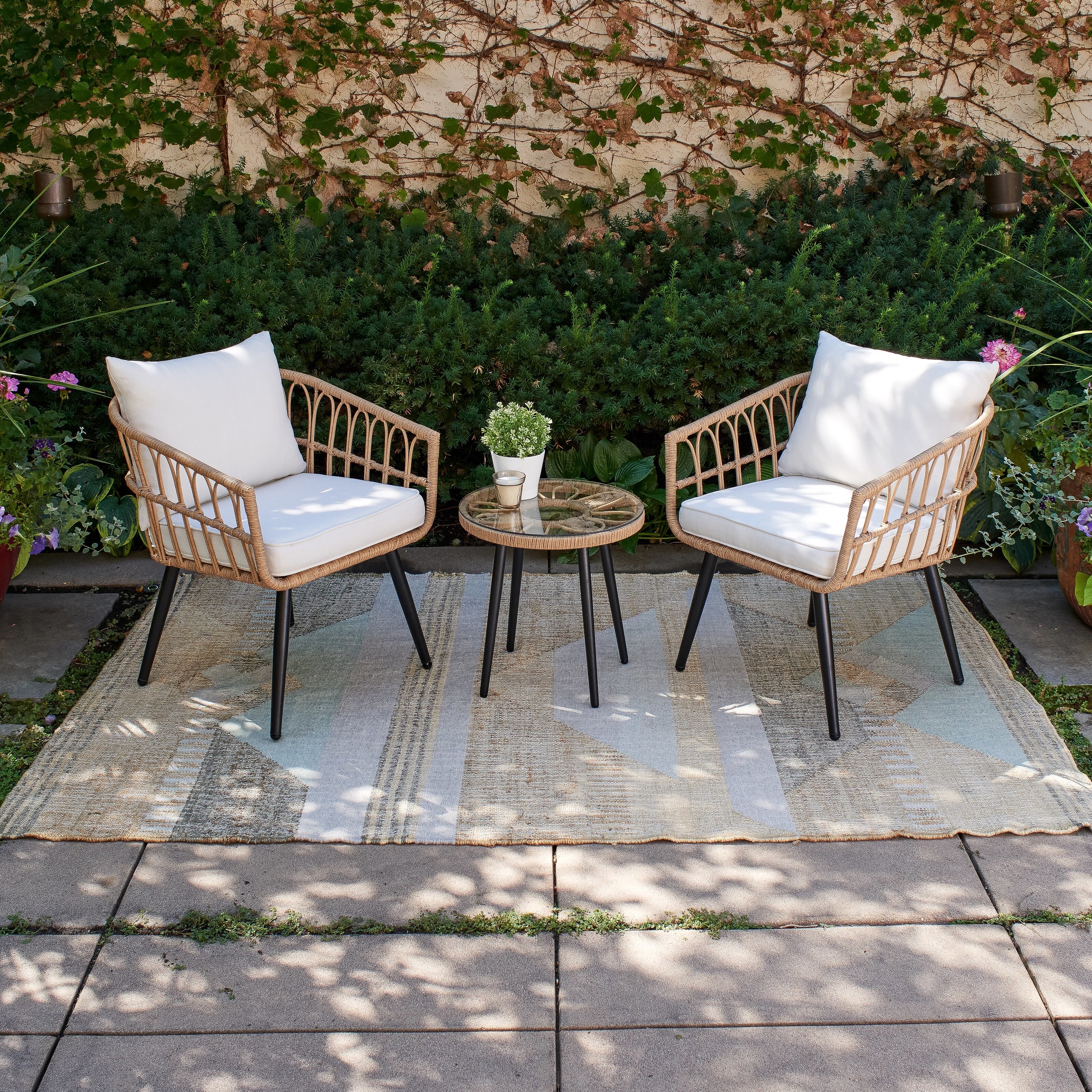 The two chairs and table on an outdoor rug