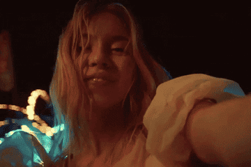 Sydney looking into the camera as she spins around at a carnival