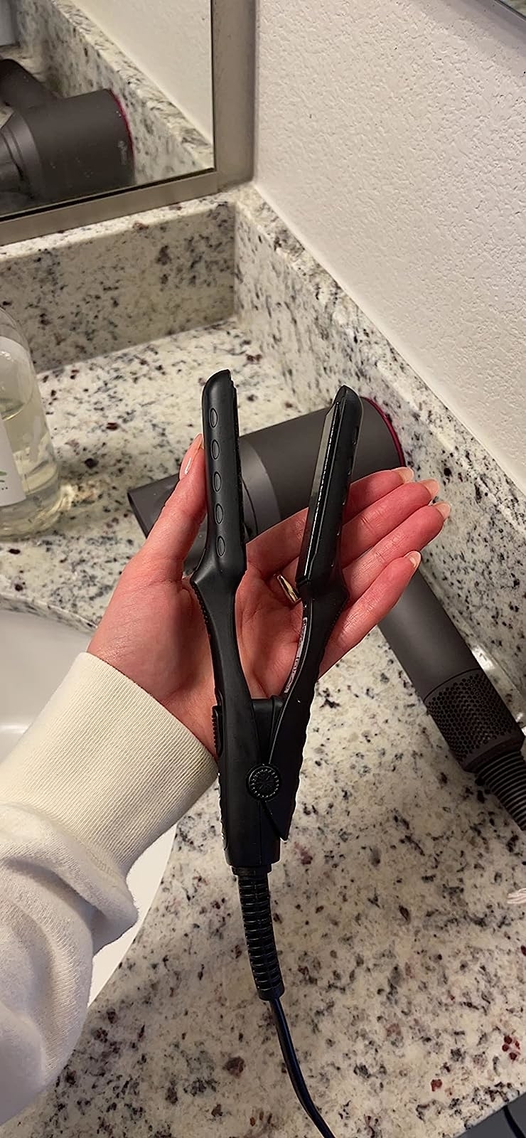 reviewer holding the mini flatiron in palm of hand