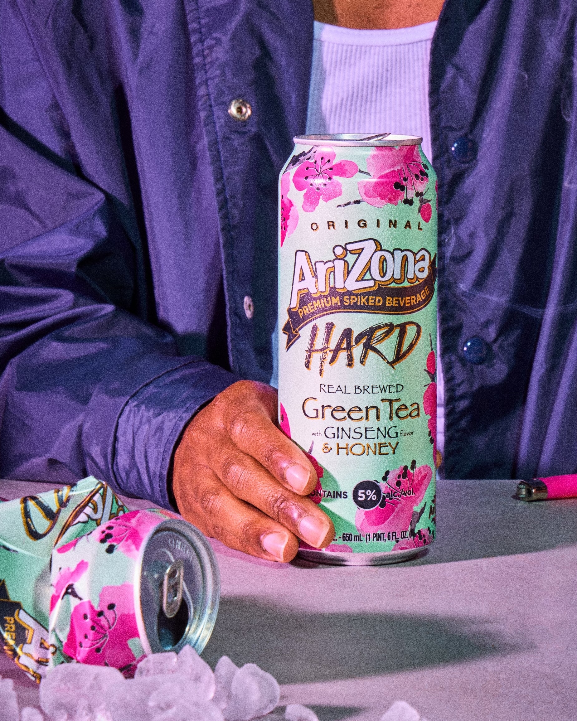 A person holds a can of AriZona Hard