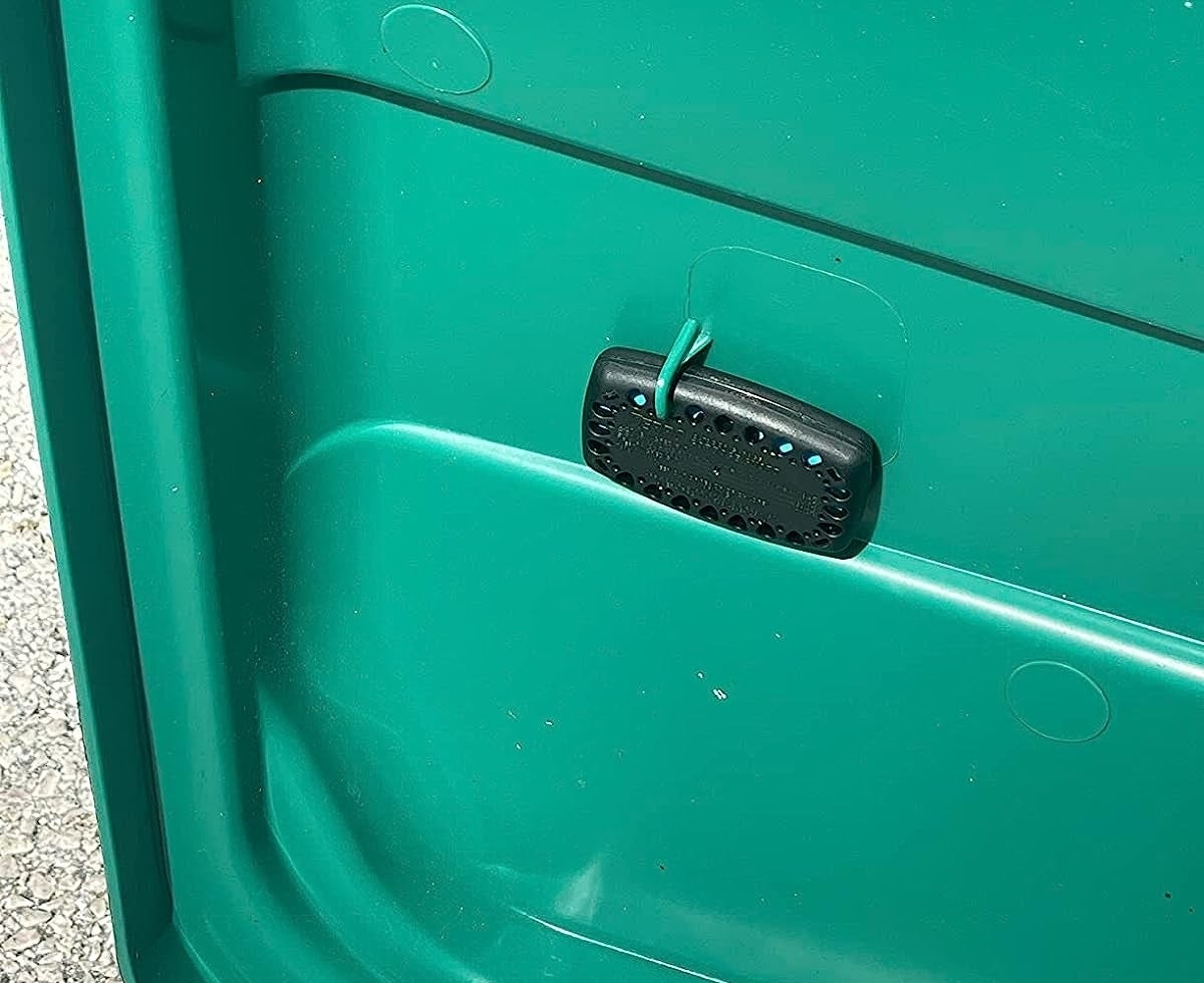 a reviewer photo of the black bug strip attached to the lid of a green outdoor trash can