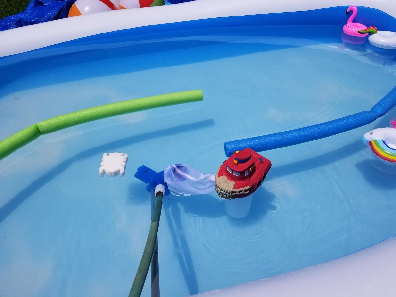 a reviewer photo of the white sponge floating on the top of a pool with toys