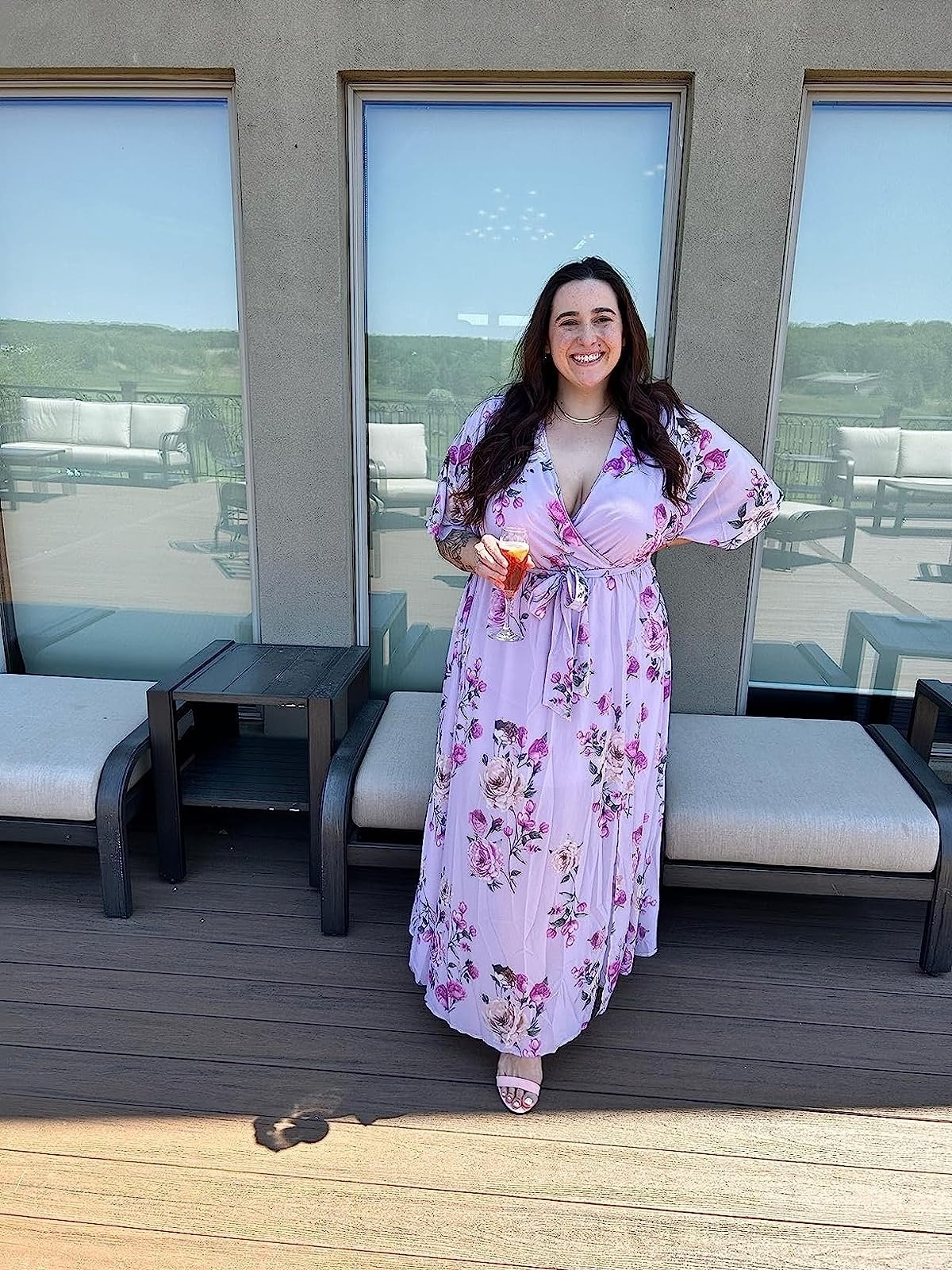 reviewer wearing three-quarter sleeve wrap-front purple dress with pink flowers