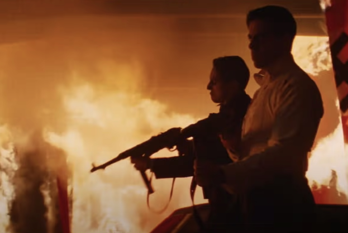 Two men holding guns in a burning room