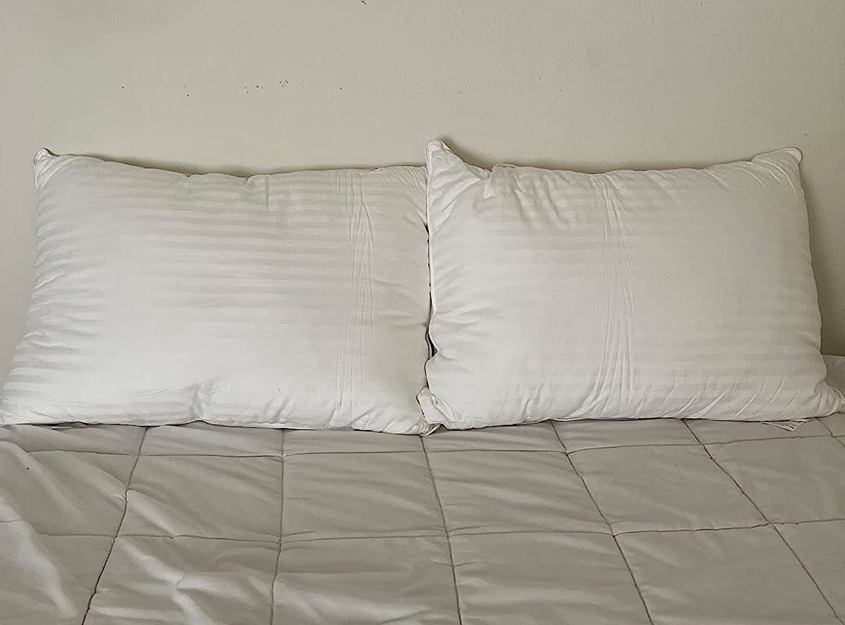 a reviewer photo of the white pillows on a white bed