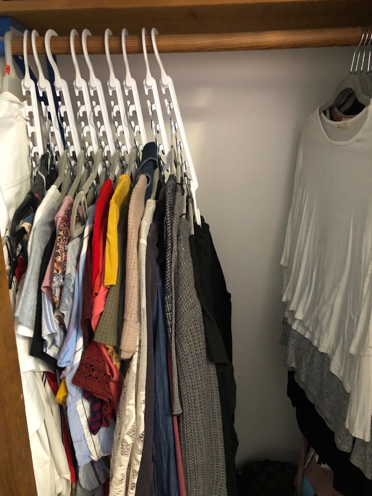 a reviewer photo of clothes on the wonder hangers that takes up about half of the closet