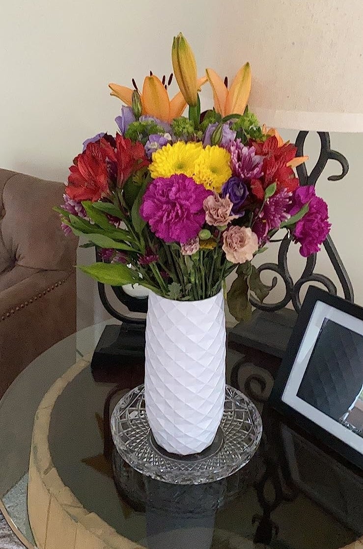a reviewer photo of a colorful bouquet of flowers in the white faceted vase