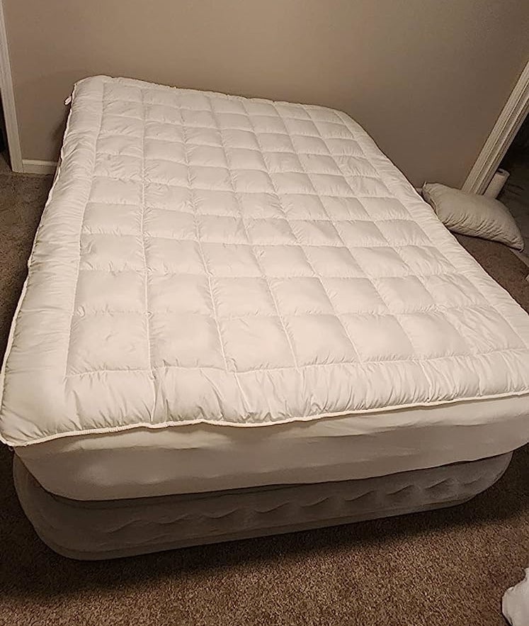 a reviewer photo of the white mattress pad on an air mattress
