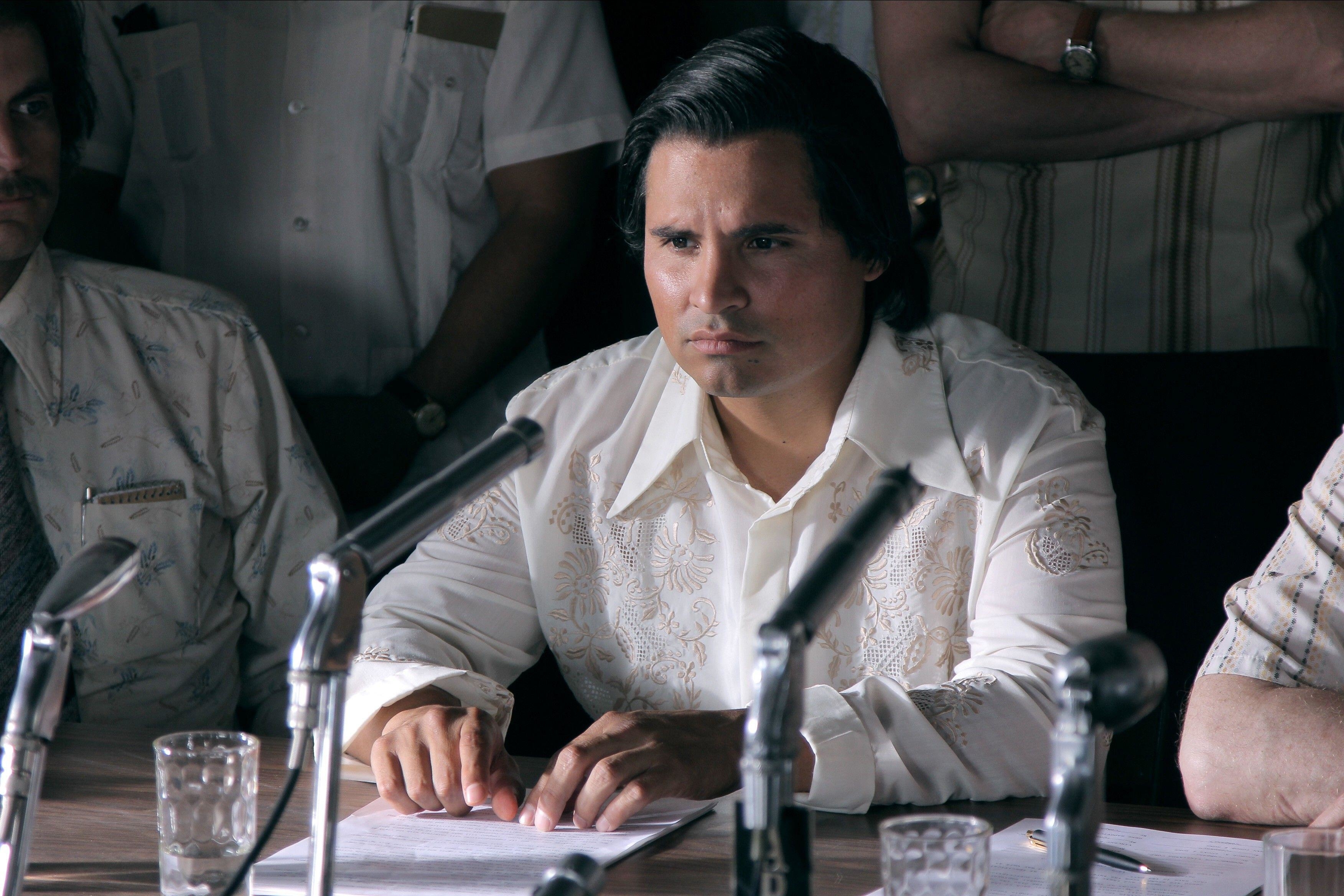 Michael Pena sits intensely near a microphone