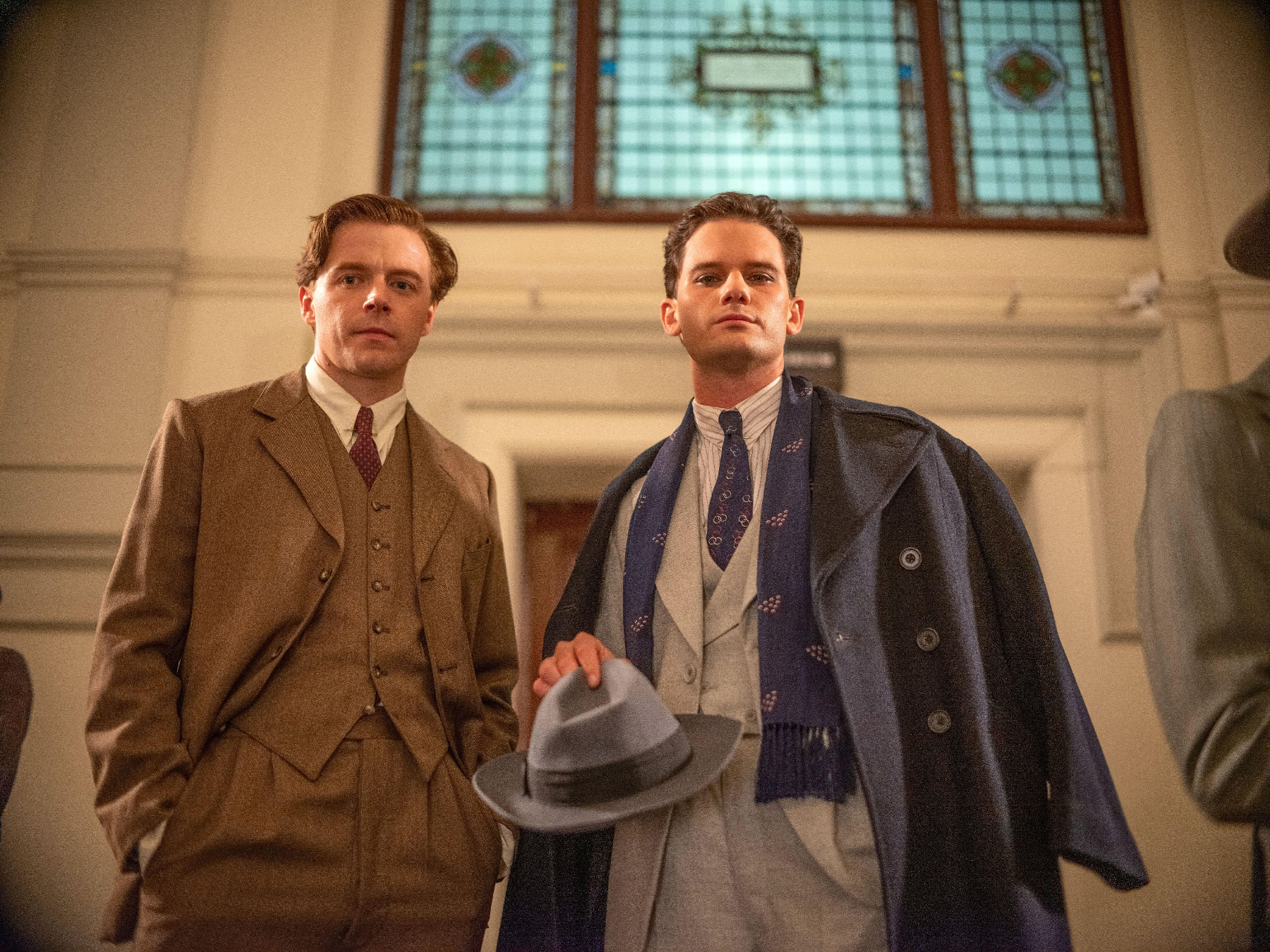 Jeremy Irvine and Jack Lowden stand in vintage suits
