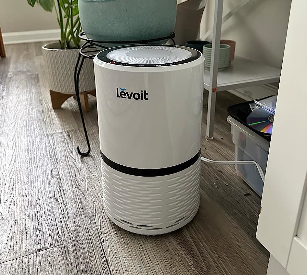 a reviewer photo of the white air purifier in a decorated office space