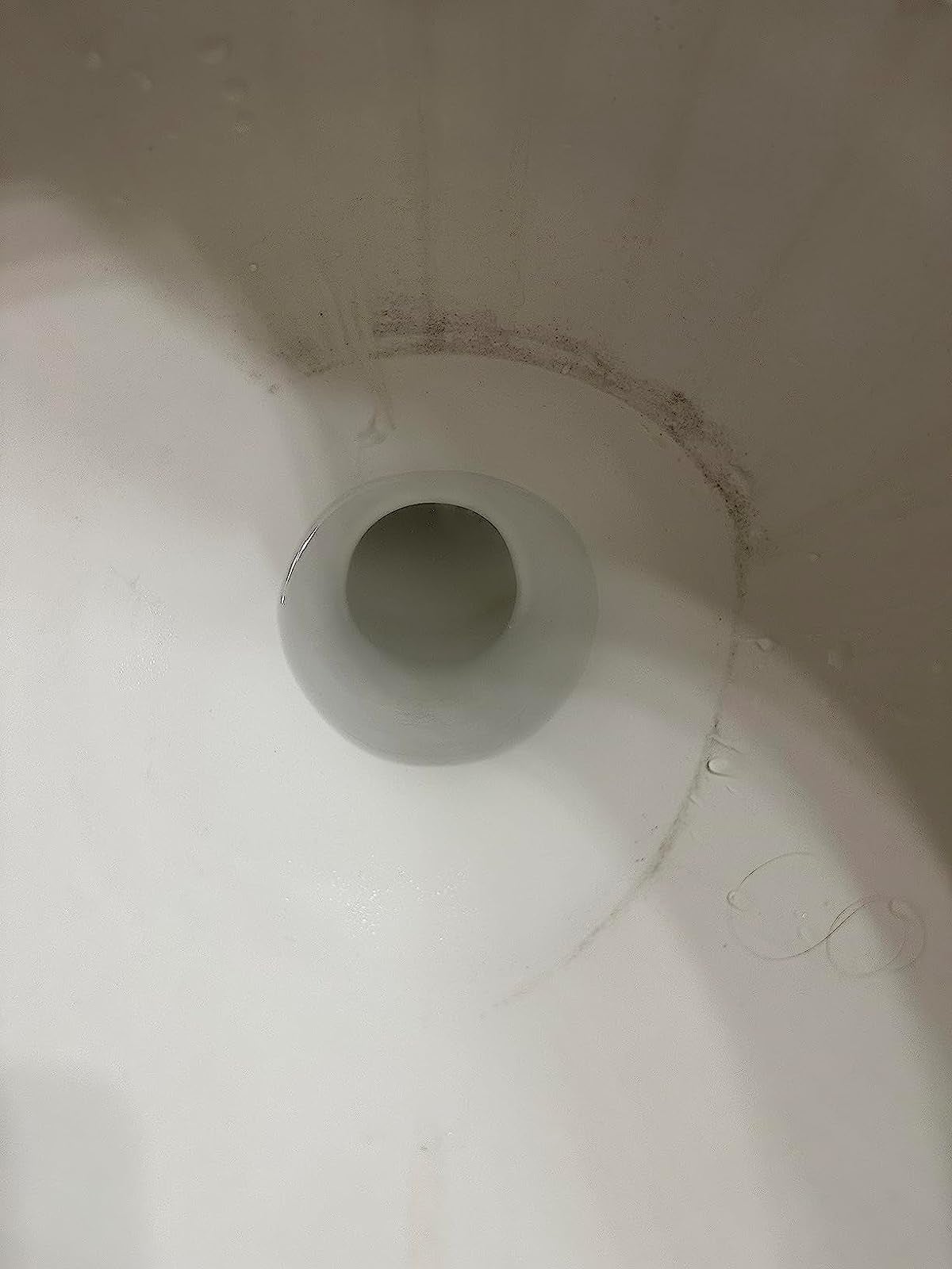 a reviewer photo of a toilet with half of the dark ring completely scrubbed away
