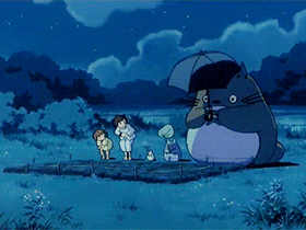 The group lifts their hands to the sky, Totoro holding an umbrella.