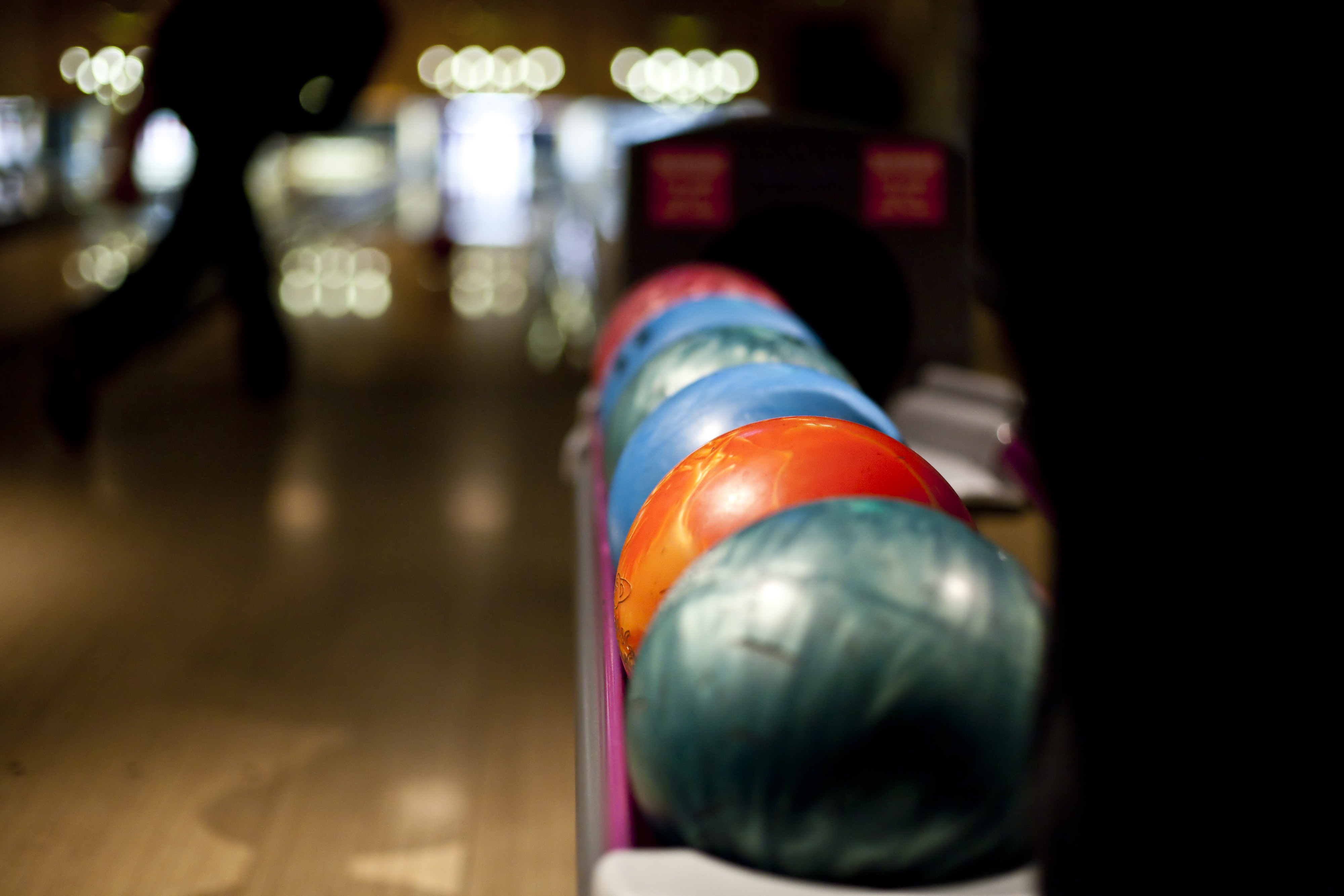 Bowling balls lined up at a bowling alley lane