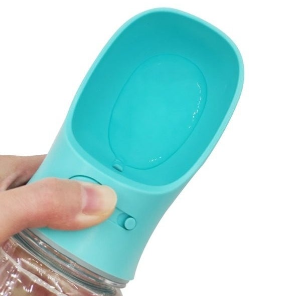 Pet water bottle with a person&#x27;s thumb