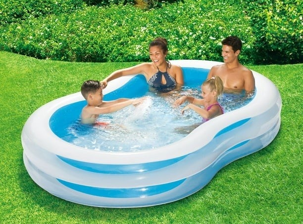 A family of four sitting in and enjoying the inflatable lagoon pool.