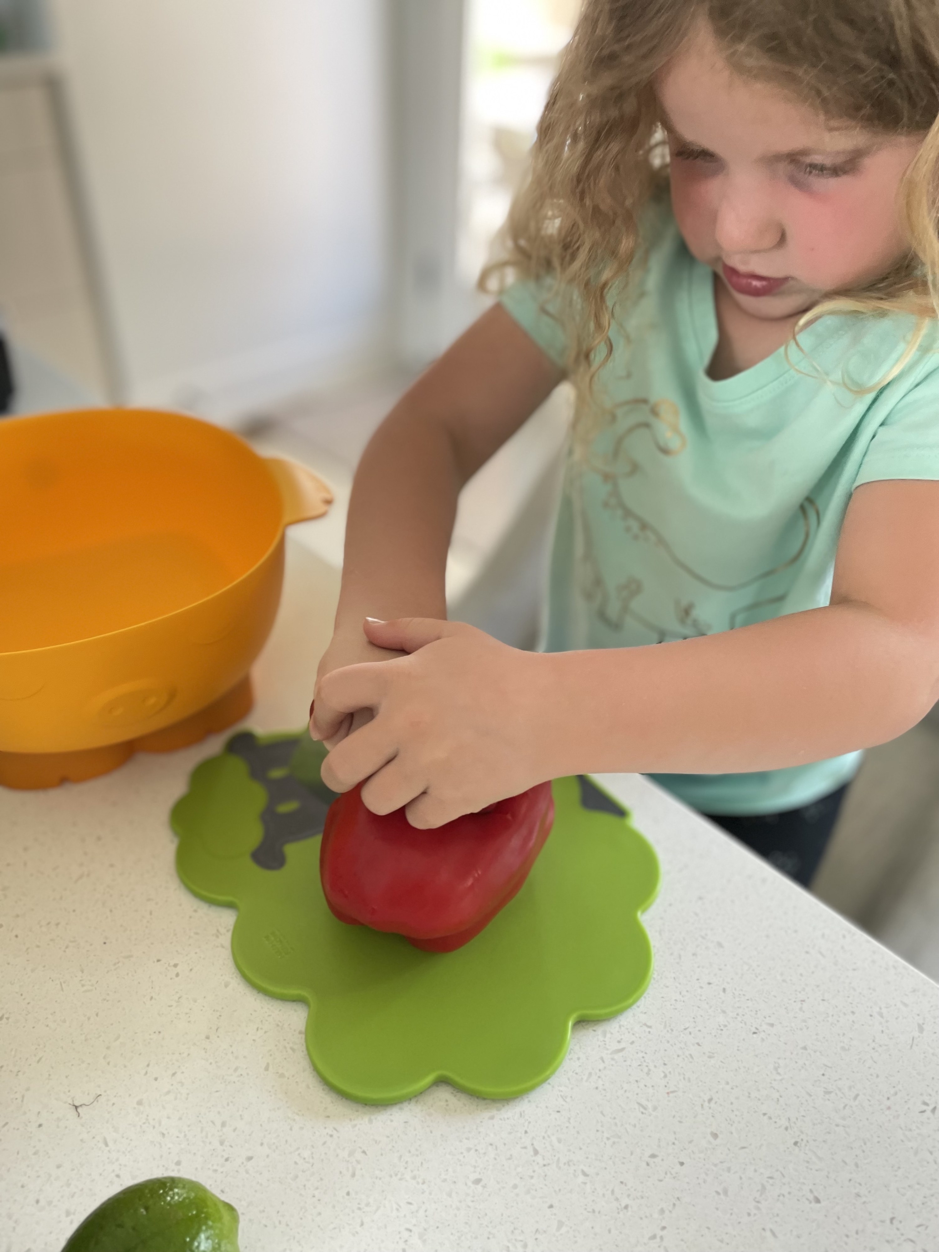 The author&#x27;s daughter cutting a bell pepper