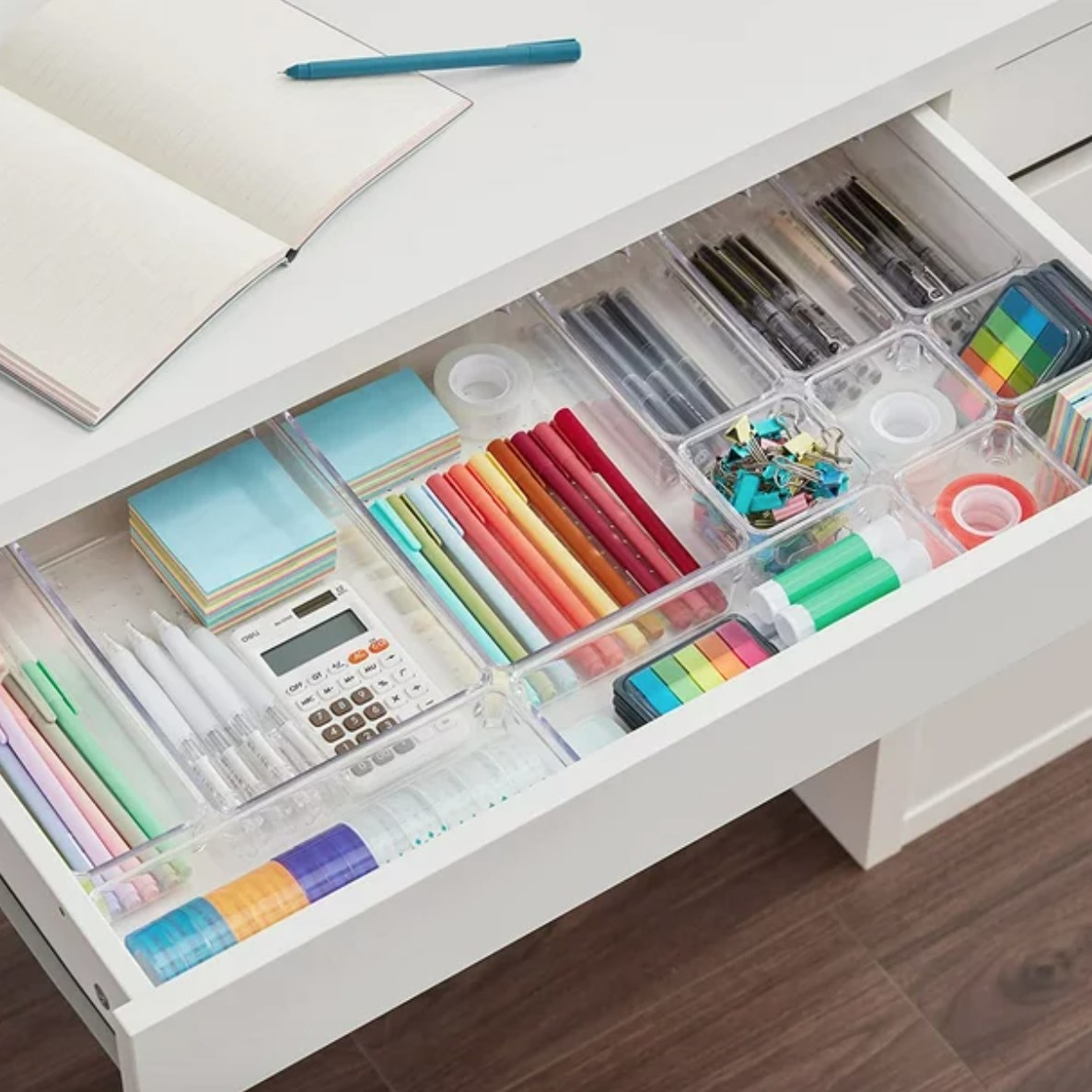 a drawer with bins used to organize office supplies
