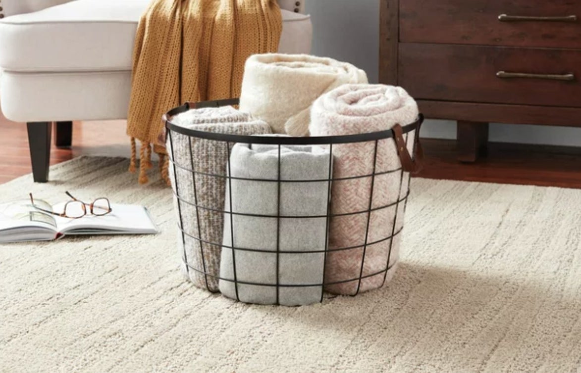 A wire basket with towels in it