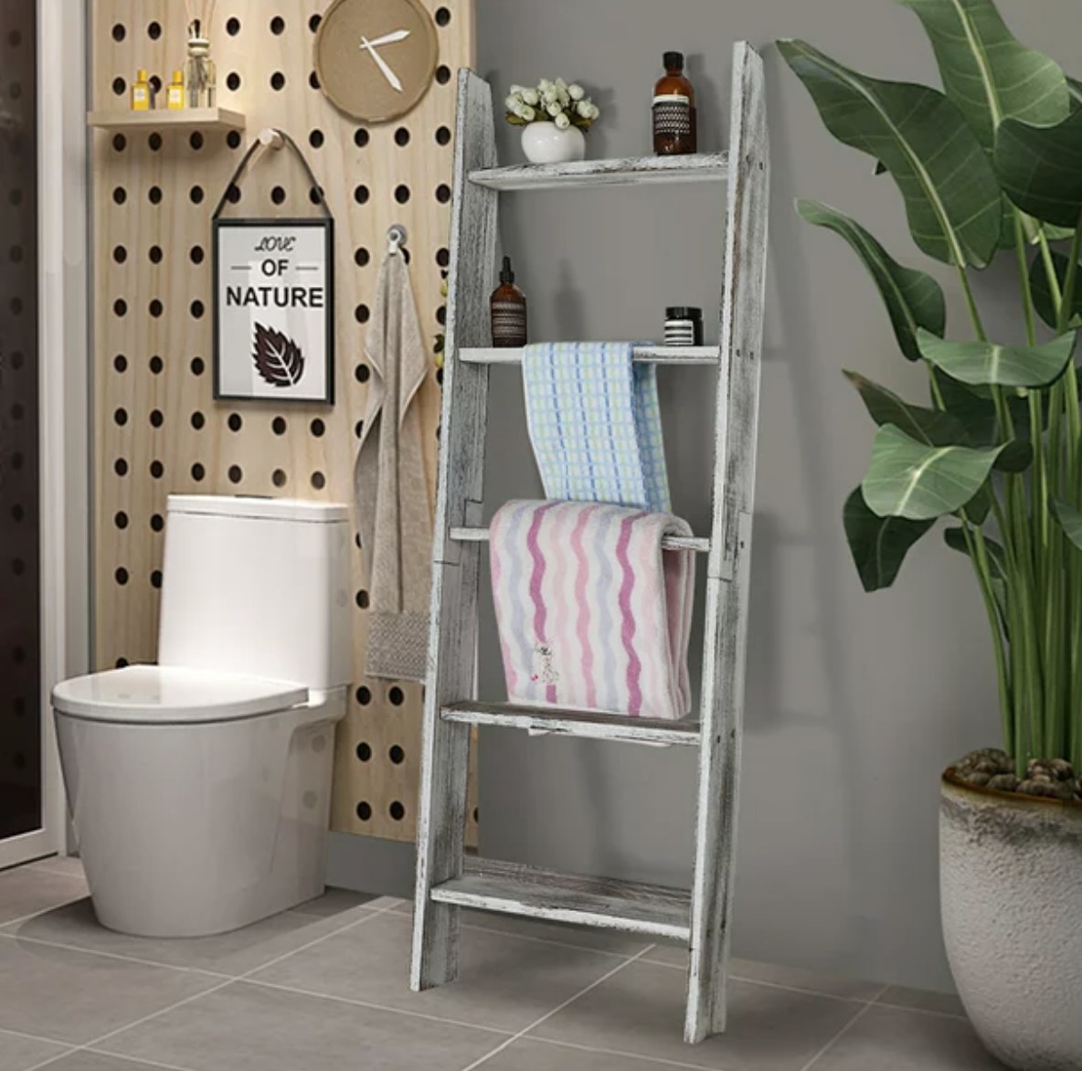 a wooden ladder with towels and bath supplies on it in a bathroom