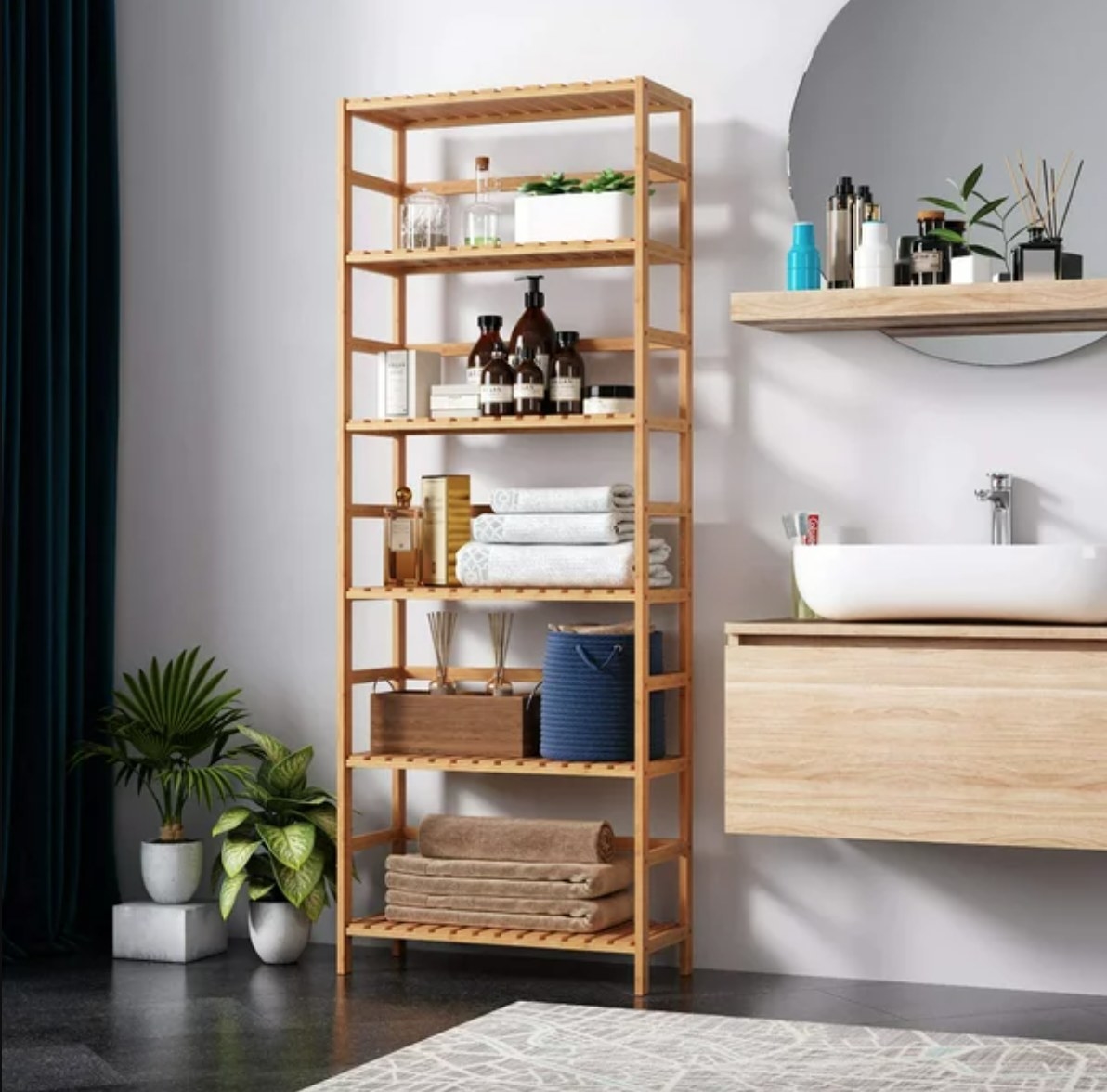 a bamboo shelf with bathroom supplies and towel organized on it in a bathroom