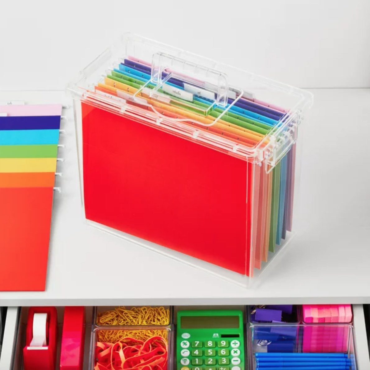 a file box with different colored filed on a desk