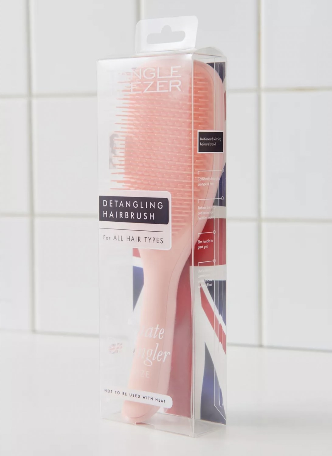 A pink detangling brush in packaging