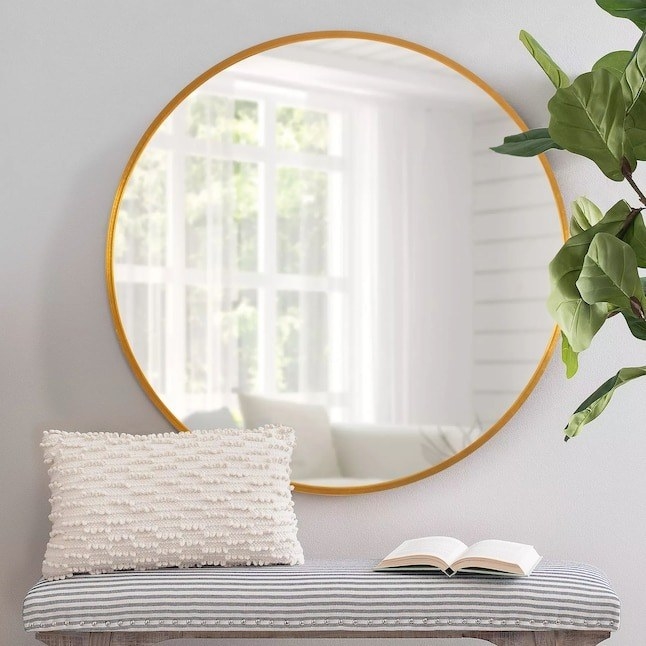 the round mirror hanging in an entryway