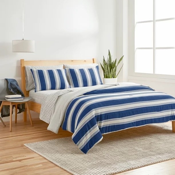 the blue and white striped comforter on a bed