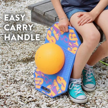 Child model holding blue and orange pogo ball by handle