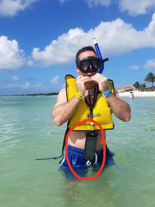 a reviewer snorkeling with the phone case around their neck