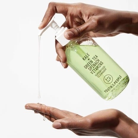 A model using a green bottle of cleanser