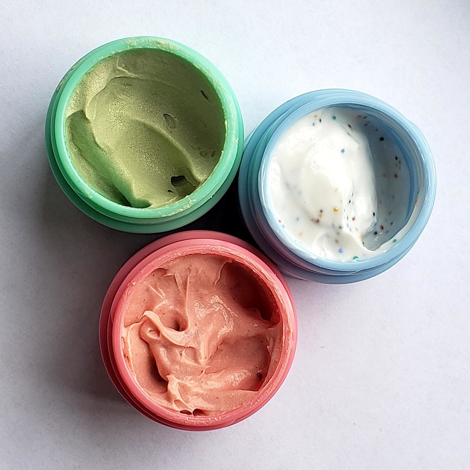 A pink, blue and green container of face masks
