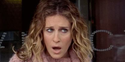 Woman with a shocked expression wearing a knit sweater